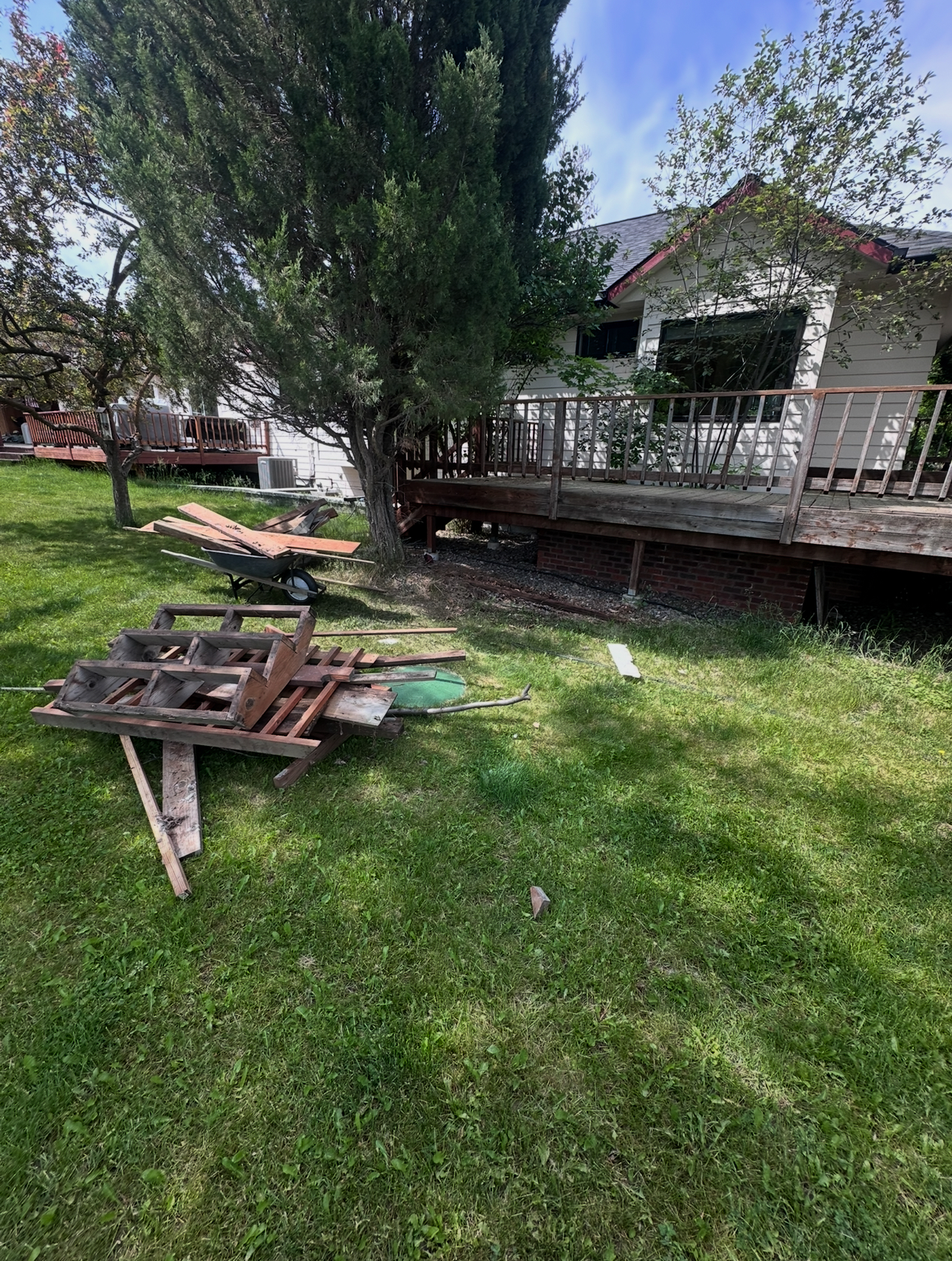 Before: Yard with scattered wood debris and construction materials